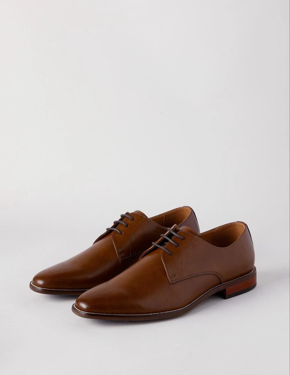 The product photo: a pair of brown leather Derby shoes